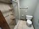 Updated bathroom featuring a glass-enclosed shower with built-in shelving and modern toilet at 1235 Cottonwood Ct, Carmel, IN 46033