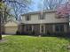 Inviting two-story home with a brick and vinyl exterior, a well-kept lawn, and flowering trees at 1235 Cottonwood Ct, Carmel, IN 46033