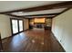 Spacious living room with hardwood floors, ceiling beams, a fireplace, built-in shelving, and glass patio doors at 1235 Cottonwood Ct, Carmel, IN 46033