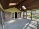 A screened porch with wood flooring, brick accents, ceiling fan, and wood paneled ceiling with skylights at 1235 Cottonwood Ct, Carmel, IN 46033