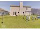 Grassy backyard showcasing a playset, a sliding glass door, and a fire pit area perfect for outdoor entertaining at 12723 Pinetop Way, Noblesville, IN 46060