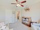Bright bedroom featuring a ceiling fan, grey carpet, and wooden shelf with storage baskets at 12723 Pinetop Way, Noblesville, IN 46060