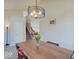 Dining area with modern light fixture over a wood table adjacent to stairs at 12723 Pinetop Way, Noblesville, IN 46060