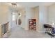 Upstairs hallway with gray carpet, sewing machine, and red bookcase at 12723 Pinetop Way, Noblesville, IN 46060
