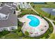 Aerial view of a community pool surrounded by lounge chairs and tables near manicured lawns and a pond at 12914 Shiraz Ln, Fishers, IN 46037