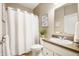 A well-lit bathroom with a single sink vanity, neutral walls, and a shower with a white curtain at 12914 Shiraz Ln, Fishers, IN 46037