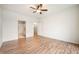 A large bedroom featuring a ceiling fan, neutral walls, wood flooring, and access to other rooms at 12914 Shiraz Ln, Fishers, IN 46037