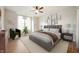 Cozy bedroom with a ceiling fan, large bed, a gallery wall, and a sitting area next to the window at 12914 Shiraz Ln, Fishers, IN 46037