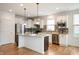 A modern kitchen with white cabinets, stainless steel appliances, and a center island with granite countertops at 12914 Shiraz Ln, Fishers, IN 46037