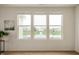 Living room offering a view of a serene pond and fountain through three large windows at 12914 Shiraz Ln, Fishers, IN 46037