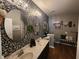 Stylish bathroom boasts dual vanities with round mirrors and a decorative black and white floral accent wall at 1302 Country Creek Cir, Shelbyville, IN 46176
