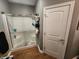 Clean bathroom features a glass-enclosed shower and a three tiered storage rack for towels and toiletries at 1302 Country Creek Cir, Shelbyville, IN 46176
