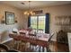 Elegant dining room with a chandelier, table set for six, and a view of the backyard at 1302 Country Creek Cir, Shelbyville, IN 46176