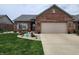 Charming brick home with a well-maintained front yard and attached two-car garage at 1302 Country Creek Cir, Shelbyville, IN 46176