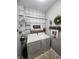 Well-organized laundry room features side-by-side washer and dryer units and a decorative, gray and white accent wall at 1302 Country Creek Cir, Shelbyville, IN 46176