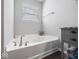 Bright bathroom featuring a soaking tub, grey vanity, and modern fixtures at 1305 Bontrager Ln, Shelbyville, IN 46176