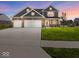 Charming two-story home with a brick and gray facade, three-car garage, and well-manicured lawn at 1305 Bontrager Ln, Shelbyville, IN 46176