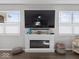 Cozy living room fireplace is flanked by two windows and features a mounted television at 1305 Bontrager Ln, Shelbyville, IN 46176