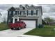 Charming two-story home showcasing a brick and gray siding, a two car garage, and well-manicured lawn at 1573 Vera Blvd, Danville, IN 46122