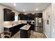 Updated kitchen with stainless steel appliances, dark cabinets, and an island at 1573 Vera Blvd, Danville, IN 46122