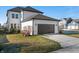Exterior view of a home with a dark colored garage door, nice landscaping, and a well-manicured lawn at 1614 Waterleaf Dr, Westfield, IN 46074