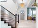 Bright foyer with staircase, light hardwood floors, and modern light fixture at 1614 Waterleaf Dr, Westfield, IN 46074