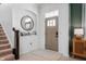 Bright foyer featuring a round mirror, staircase, and stylish decor at 1614 Waterleaf Dr, Westfield, IN 46074