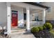 Inviting front porch with a red door, house number, and manicured bushes at 1614 Waterleaf Dr, Westfield, IN 46074