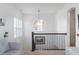 Bright hallway featuring a stylish light fixture, wood railing, and view of the staircase at 1614 Waterleaf Dr, Westfield, IN 46074