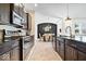 Gourmet kitchen with dark wood cabinets, stainless steel appliances, granite countertops, and stylish backsplash at 1614 Waterleaf Dr, Westfield, IN 46074
