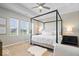 Bright main bedroom featuring a four-poster bed, neutral decor, and abundant natural light from the windows at 1614 Waterleaf Dr, Westfield, IN 46074