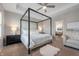 Main bedroom with tray ceiling, canopy bed, and a seating area. En-suite bathroom access at 1614 Waterleaf Dr, Westfield, IN 46074