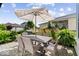 Back patio features a woven outdoor dining set, a large patio umbrella, and vibrant landscaping at 1614 Waterleaf Dr, Westfield, IN 46074
