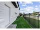 Side yard features a black metal fence, a brick foundation, and lush green lawn and plantings at 1614 Waterleaf Dr, Westfield, IN 46074