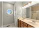 Bathroom with double sink vanity, a large mirror and tiled shower/tub enclosure at 16350 Quartz Dr, Noblesville, IN 46060