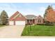 Charming single-story brick home featuring a well-manicured lawn and an attached two-car garage at 16350 Quartz Dr, Noblesville, IN 46060