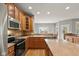 Spacious kitchen featuring stainless steel appliances, wood cabinets, and center island with a view to the living area at 16350 Quartz Dr, Noblesville, IN 46060