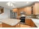 Well-equipped kitchen with stainless steel appliances, wood cabinetry, and island counter at 16350 Quartz Dr, Noblesville, IN 46060