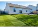 Well-maintained backyard with green grass, a stone patio, and sliding glass doors at 1696 Carlton Dr, Greenfield, IN 46140