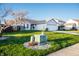 View of front yard featuring mature tree, green grass, and utility box with rock surround at 1696 Carlton Dr, Greenfield, IN 46140