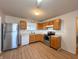 View of kitchen with stainless steel refrigerator, wooden cabinets, and updated appliances at 1696 Carlton Dr, Greenfield, IN 46140