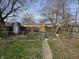 A grassy backyard with a metal shed and a weathered fence under a blue sky with bare trees at 1710 Thaddeus St, Indianapolis, IN 46203