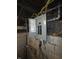 A view of a gray electrical panel with exposed wiring, and some electricals in an unfinished basement at 1710 Thaddeus St, Indianapolis, IN 46203