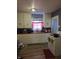 Cozy kitchen features classic white cabinets, wood countertops, and a red patterned curtain above the sink at 1710 Thaddeus St, Indianapolis, IN 46203