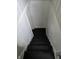 A simple staircase descending into a basement with black-painted wooden steps and white walls at 1710 Thaddeus St, Indianapolis, IN 46203