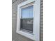 An up-close view of a window, revealing the architectural details and the street outside at 1710 Thaddeus St, Indianapolis, IN 46203