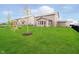 The backyard features a lush lawn, fence, playset, and patio at 17301 Tribute Row, Noblesville, IN 46060