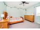 A cheerful bedroom features natural light, a ceiling fan, and pastel green walls at 17301 Tribute Row, Noblesville, IN 46060