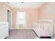 A serene Bedroom is painted pink and has a crib and changing table at 17301 Tribute Row, Noblesville, IN 46060