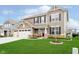Beautiful home with manicured lawn, a three-car garage, and a cozy bench on the front porch at 17301 Tribute Row, Noblesville, IN 46060